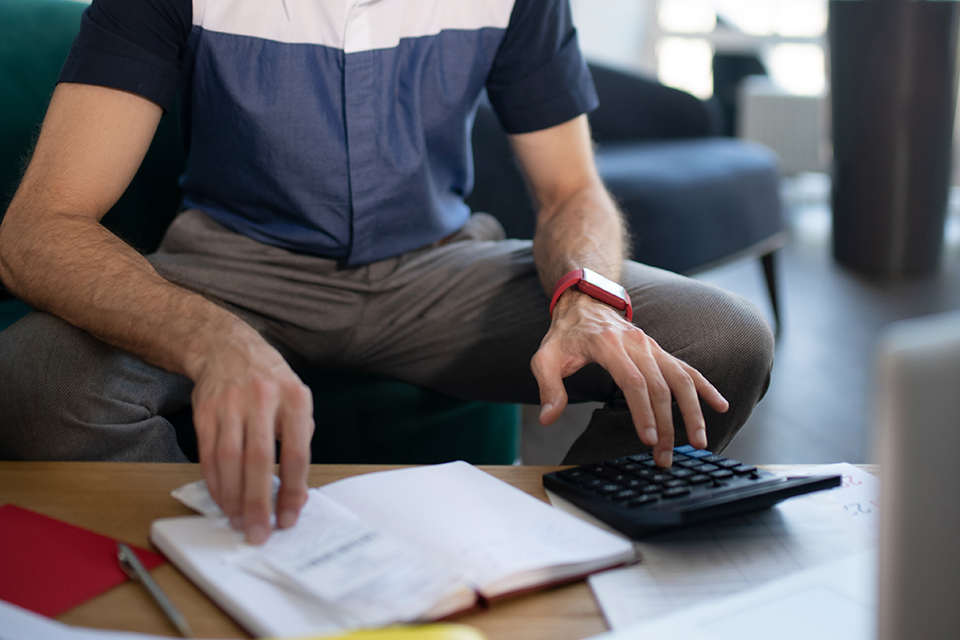 Involved in calculations. Young bearded businessman feeling involved in calculations and accounting